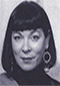 Judith Lowry black and white headshot. Judith has a blunt bob with bangs, hoop earrings, and a turtleneck shirt.