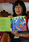 Sharol Graves headshot. Sharol is holding a book and reading aloud.