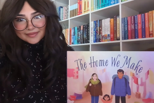 Photo of Layla Fallah-Cyphert holding THE HOME WE MAKE in front of colorful bookshelves